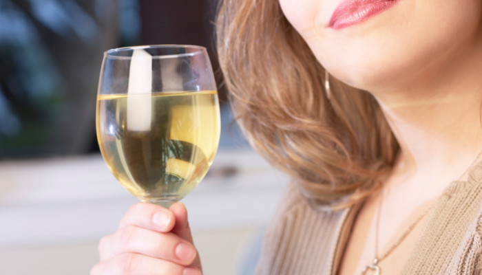 A person holding a glass of wineDescription automatically generated with medium confidence